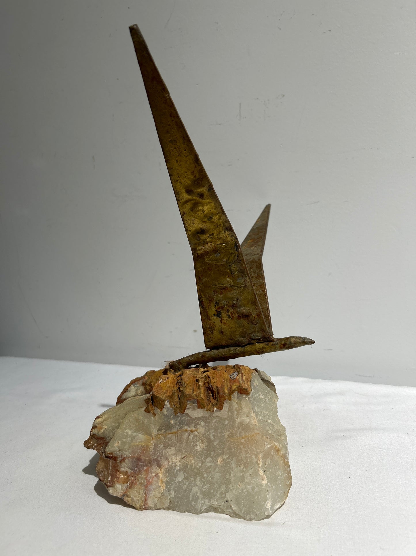 Metal bird on stone base sculpture