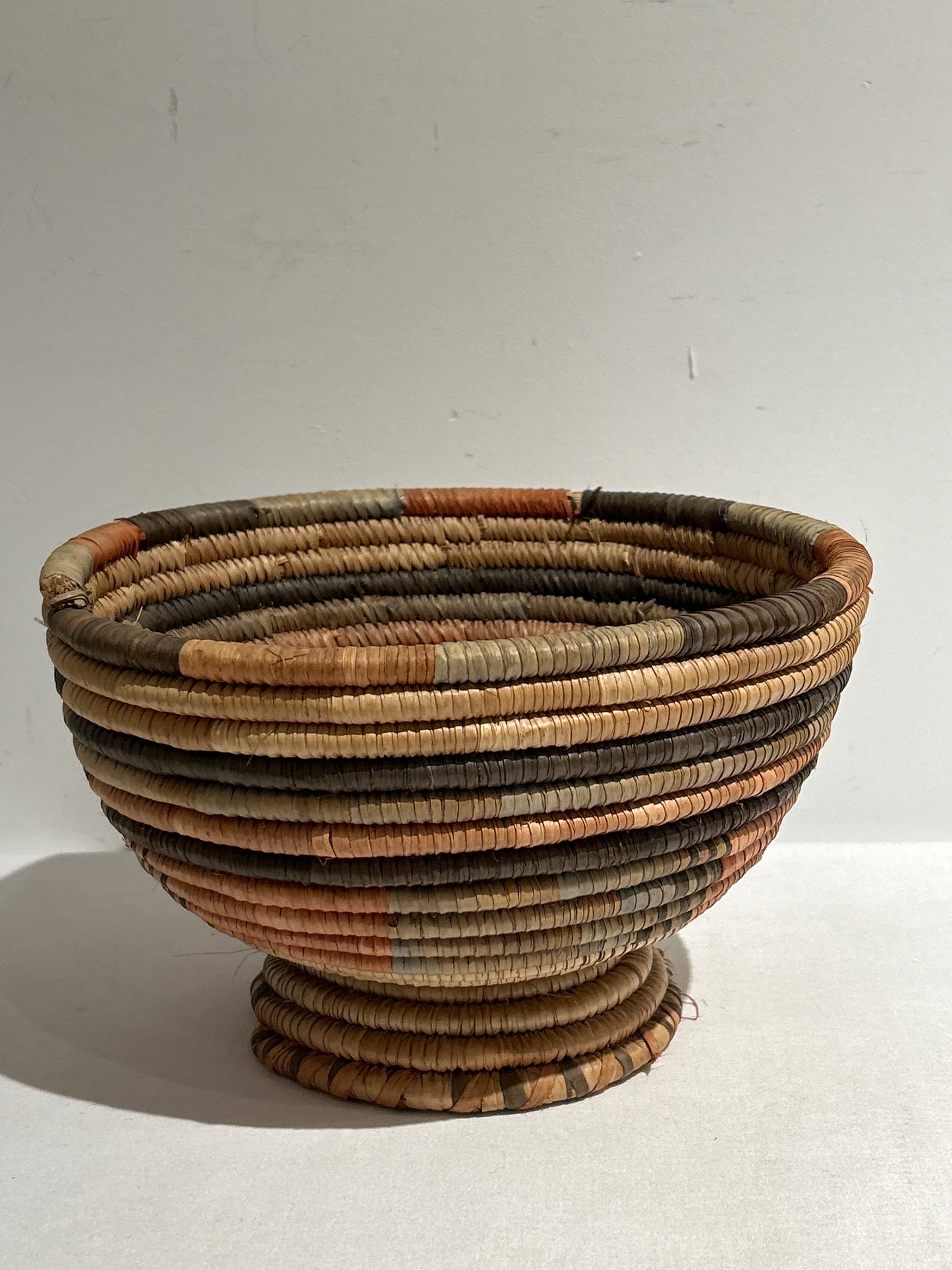 Woven basket with narrow base