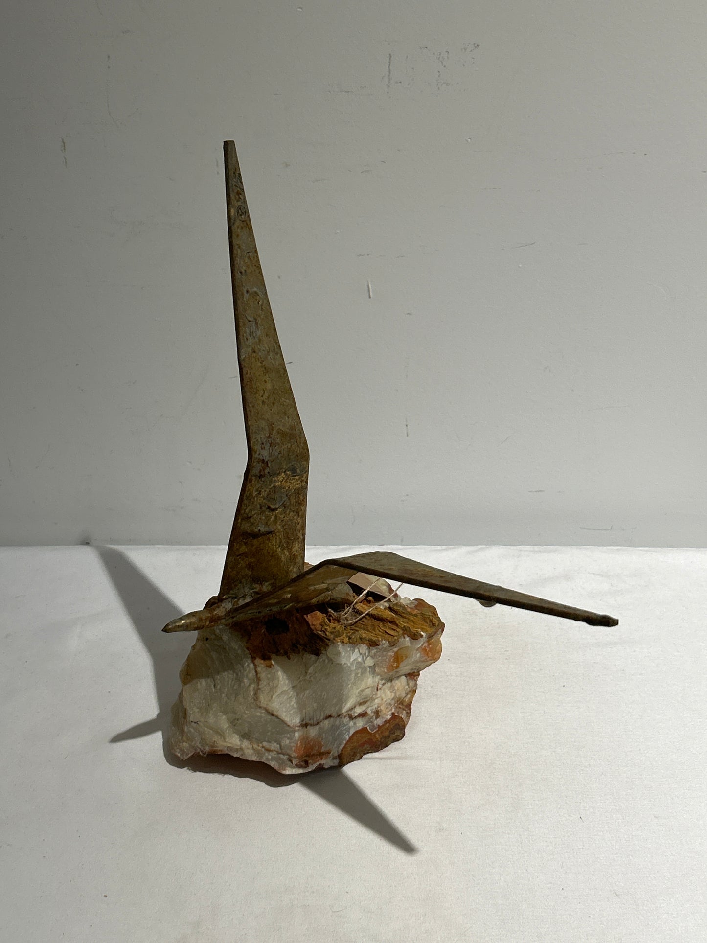 Metal bird on stone base sculpture