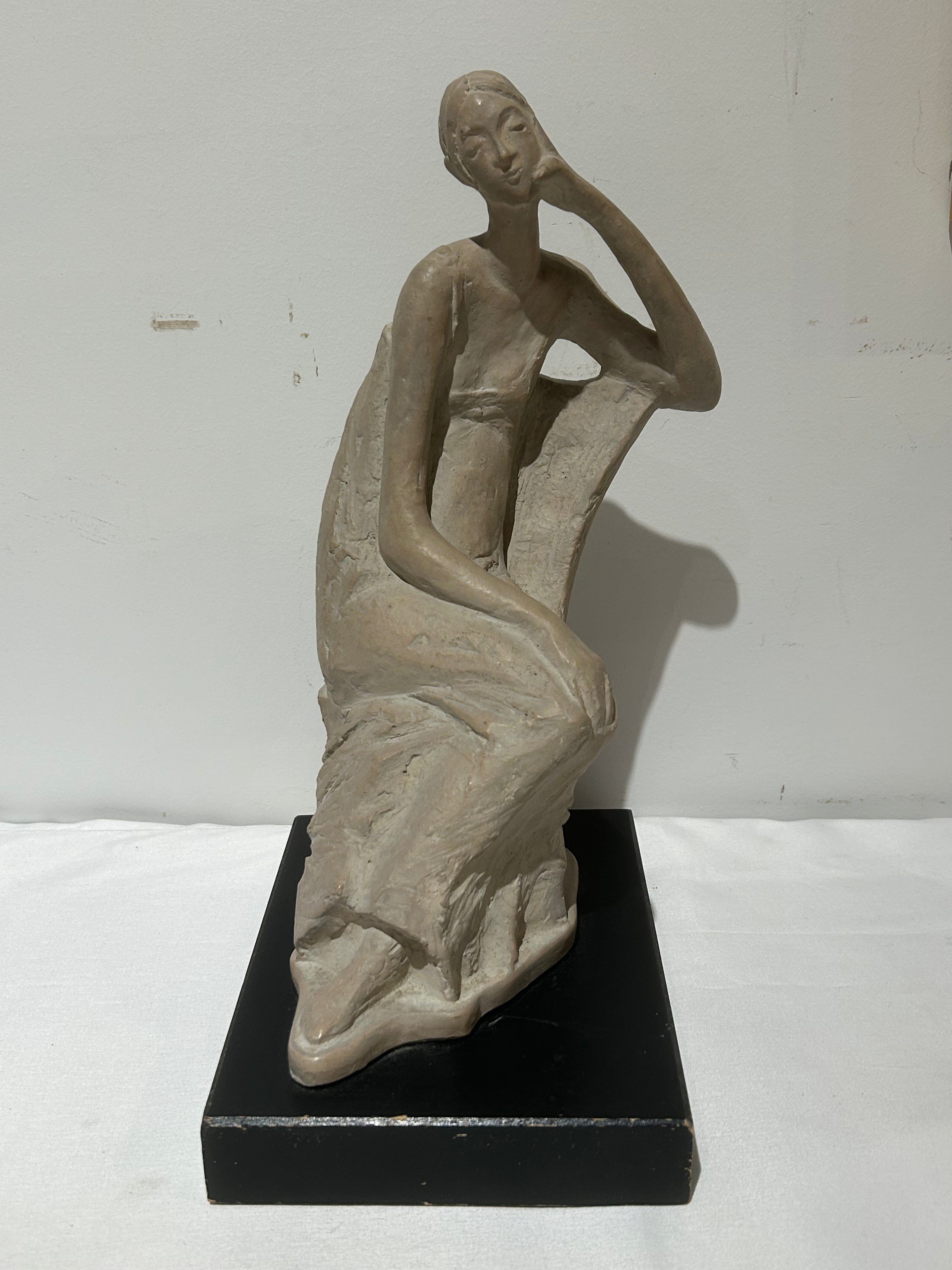 Vintage sitting figural sculpture on wood
