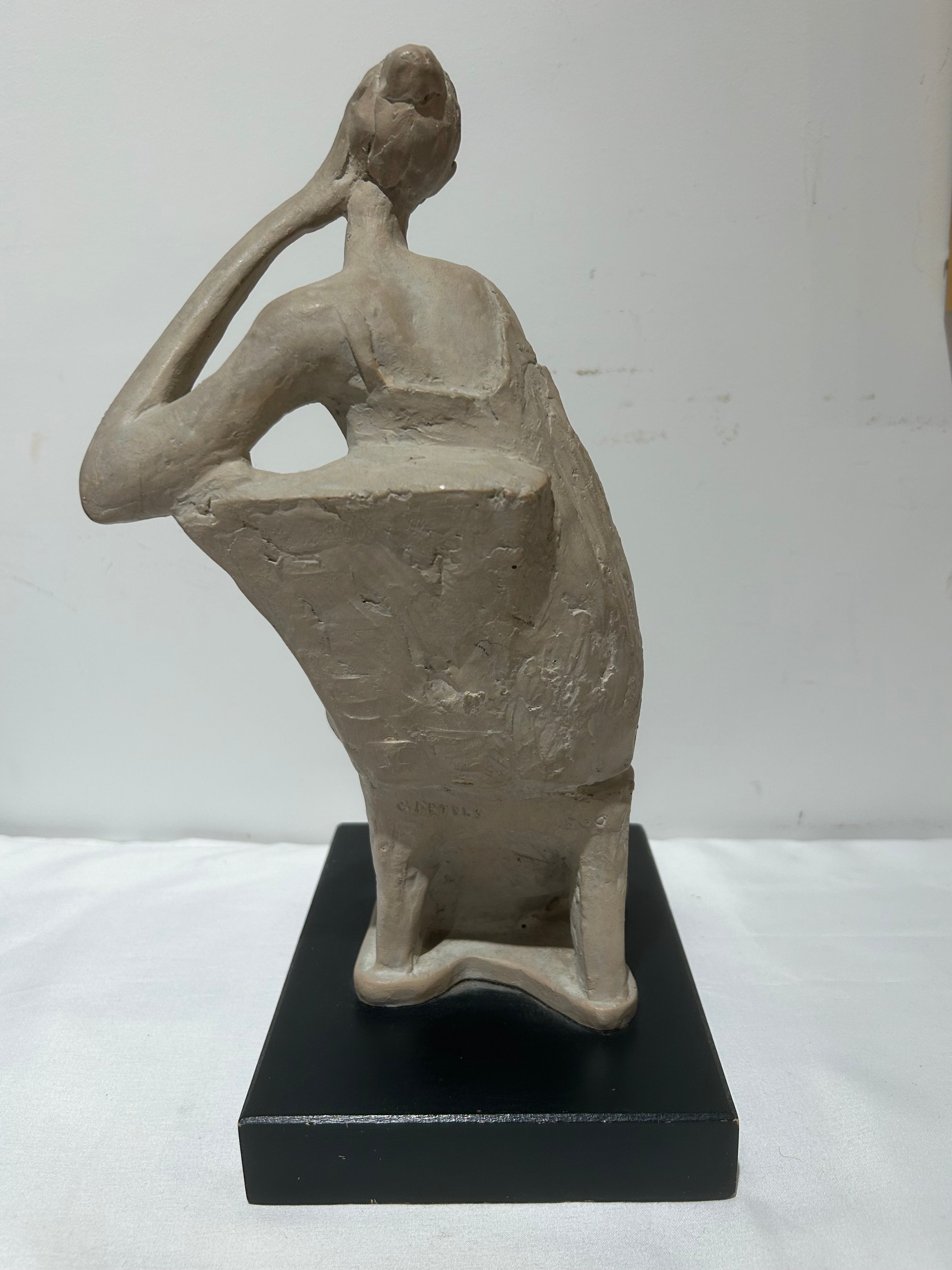 Vintage sitting figural sculpture on wood