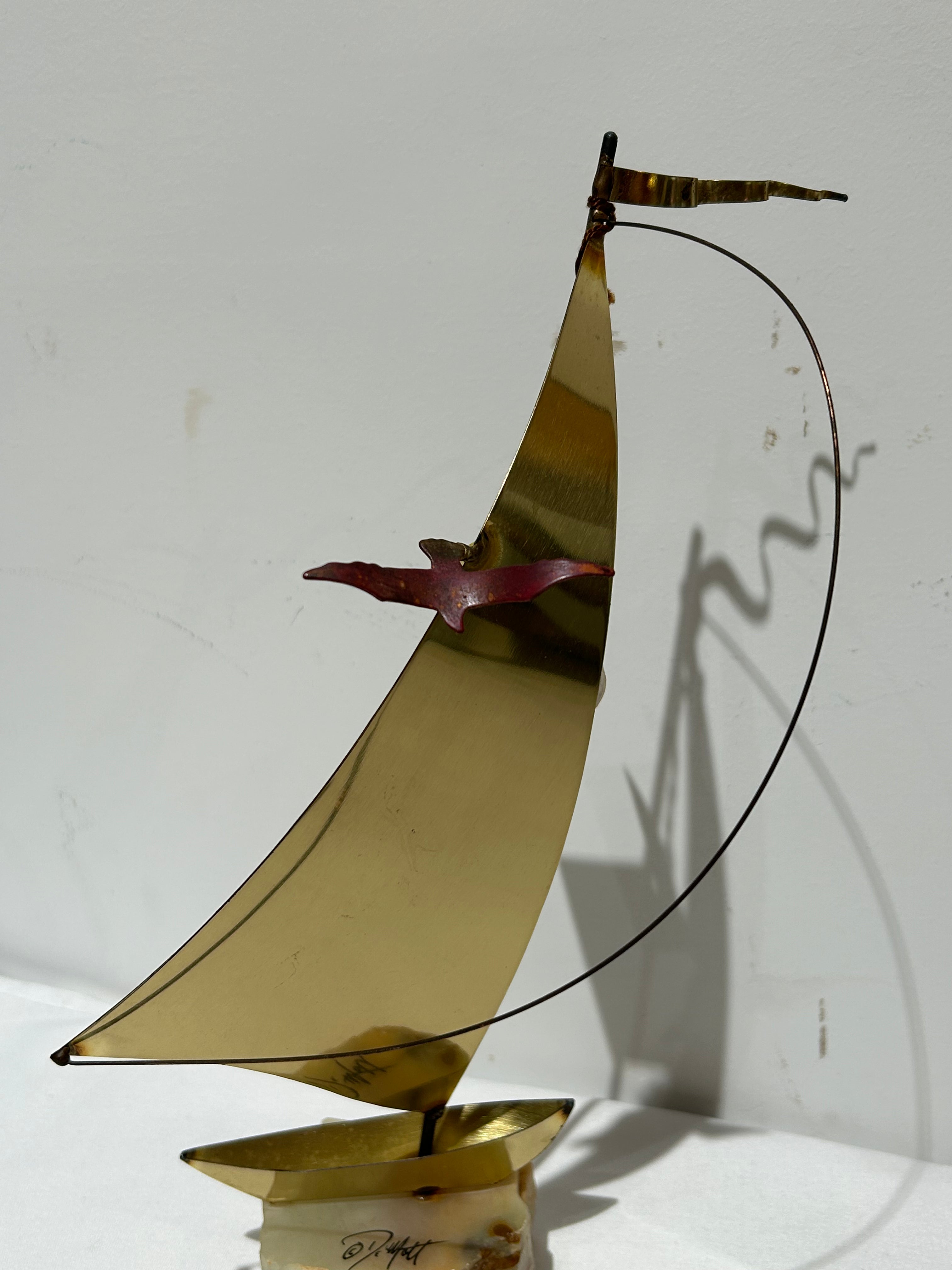 Vintage brass sailboat statue on stone