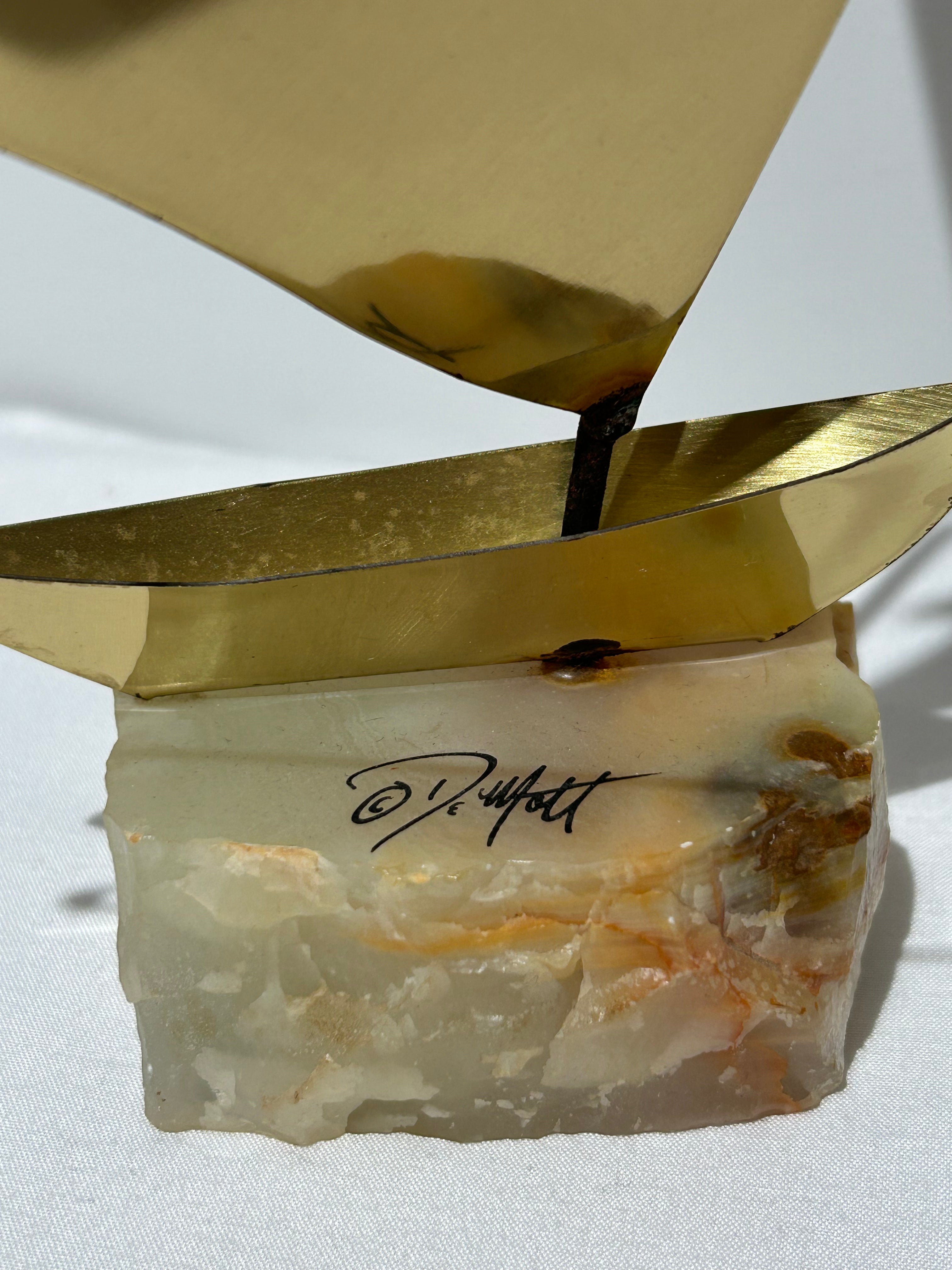 Vintage brass sailboat statue on stone