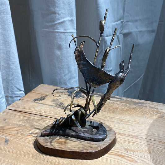 Brutalist bird sculpture on wood